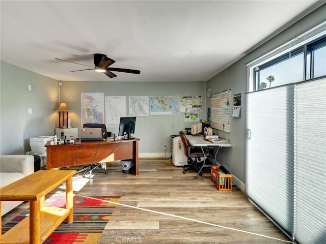 home office featuring light wood finished floors, baseboards, and ceiling fan