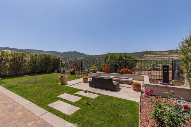 view of yard featuring a mountain view, a patio, a fenced backyard, and an outdoor living space