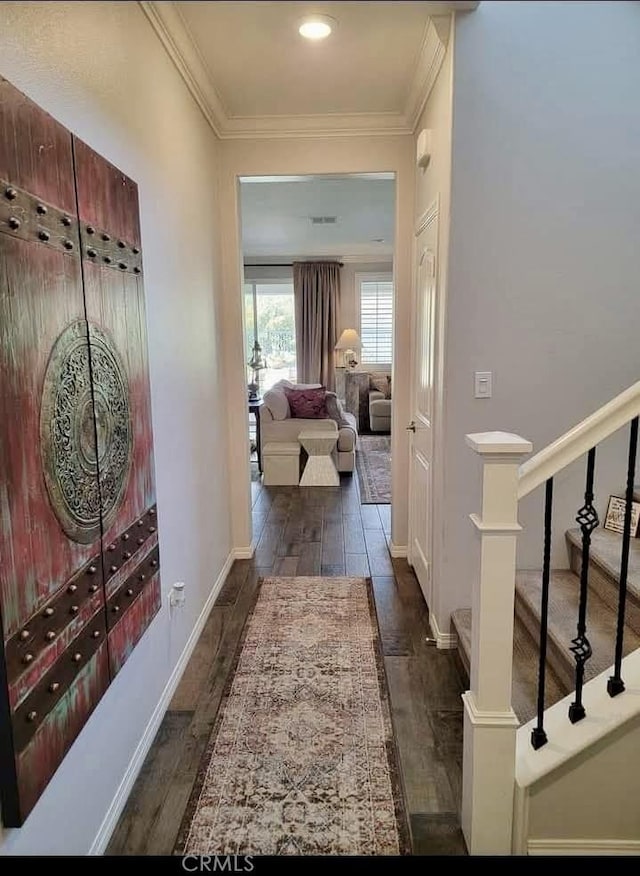 corridor featuring stairs, visible vents, ornamental molding, and wood finished floors