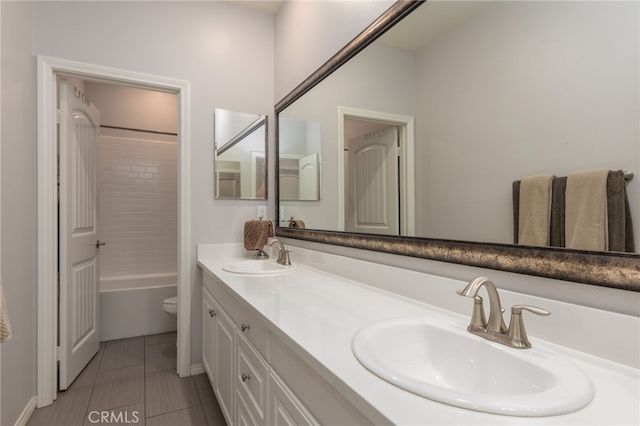 full bathroom with a sink, tile patterned flooring, toilet, and double vanity