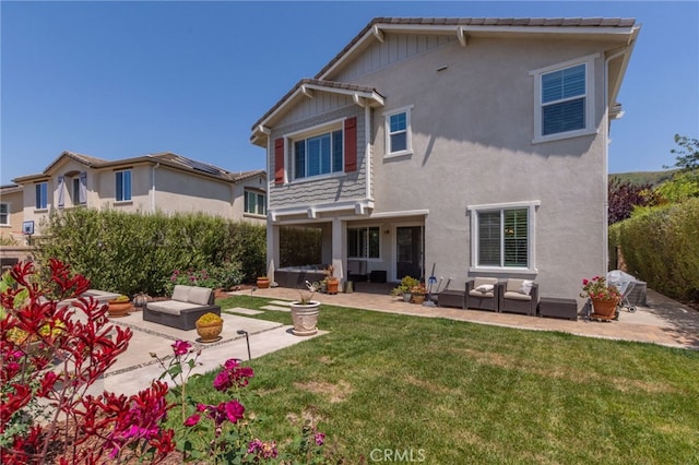 back of property featuring a yard, a patio area, stucco siding, and outdoor lounge area