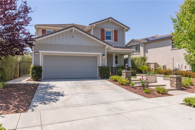 craftsman inspired home with an attached garage, driveway, and a gate