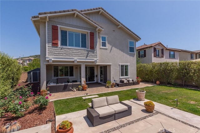 rear view of house featuring a yard, outdoor lounge area, and a patio
