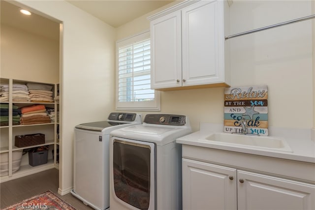 laundry area featuring wood finished floors, washing machine and dryer, recessed lighting, a sink, and cabinet space