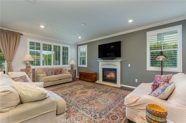 living area with crown molding, recessed lighting, baseboards, and a glass covered fireplace