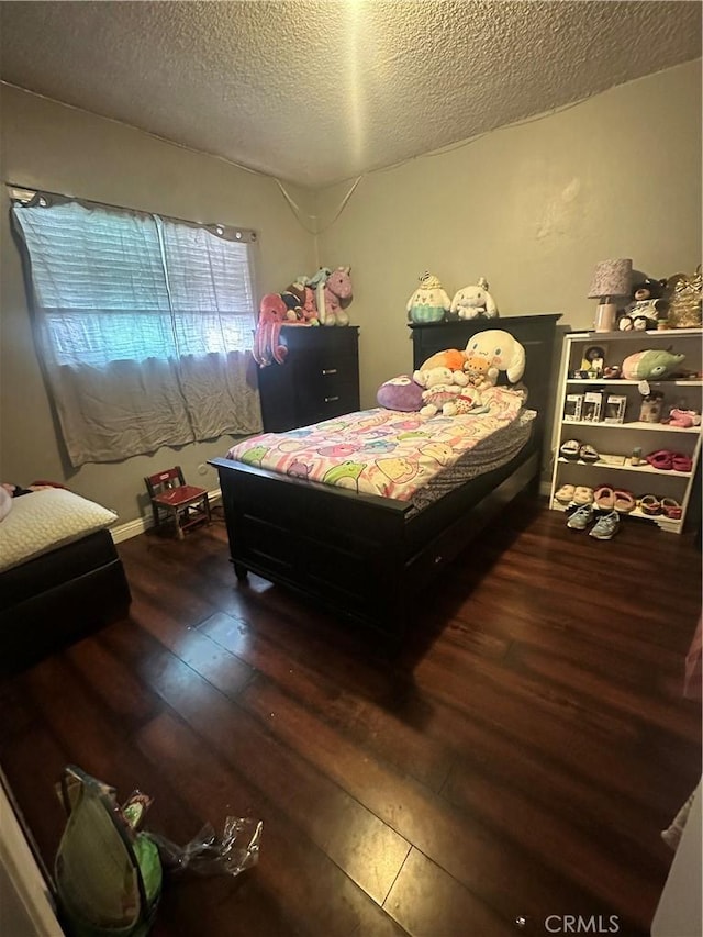 bedroom featuring wood-type flooring and a textured ceiling