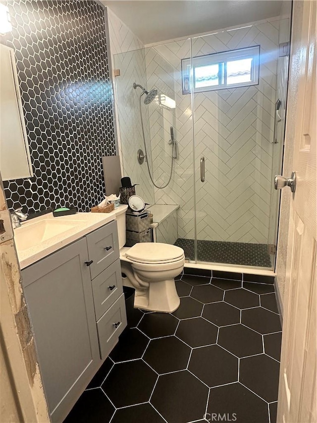 full bath with vanity, tile patterned flooring, a stall shower, and toilet