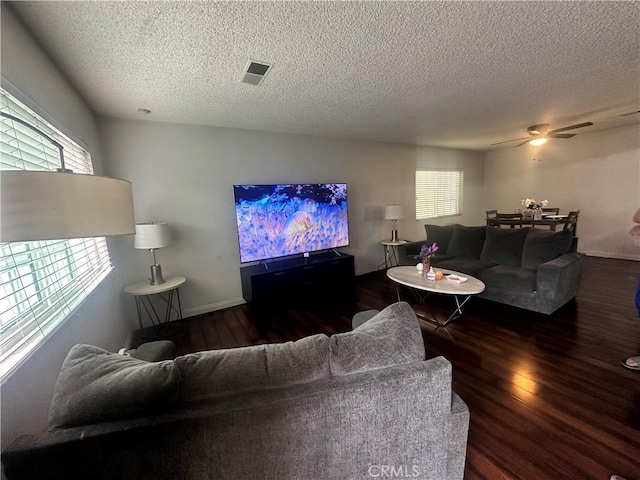 living room featuring visible vents, a textured ceiling, ceiling fan, and wood finished floors