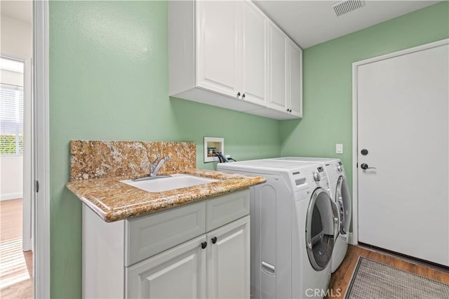 23664 Clearidge Dr, Valencia, CA 91354 - clothes washing area featuring light wood-style floors, cabinet space, and washer and clothes dryer