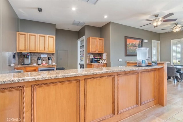 39312 Beringer Dr, Murrieta, CA 92563 - kitchen with backsplash, ceiling fan, light brown cabinetry, recessed lighting, and light stone countertops