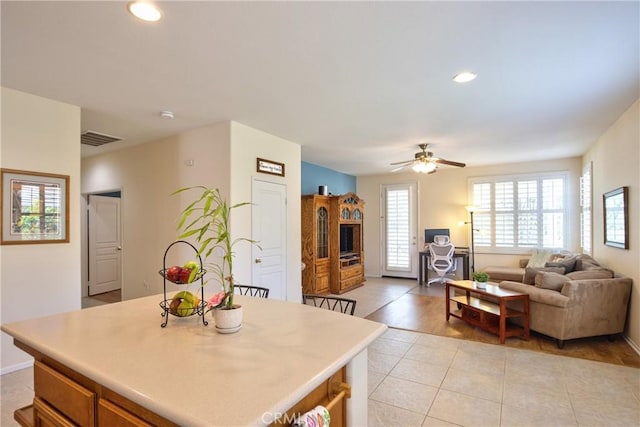39312 Beringer Dr, Murrieta, CA 92563 - kitchen with light tile patterned floors, a kitchen island, ceiling fan, recessed lighting, and light countertops