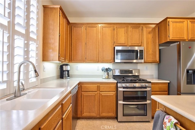 39312 Beringer Dr, Murrieta, CA 92563 - kitchen featuring stainless steel appliances, a sink, light countertops, brown cabinets, and light tile patterned floors