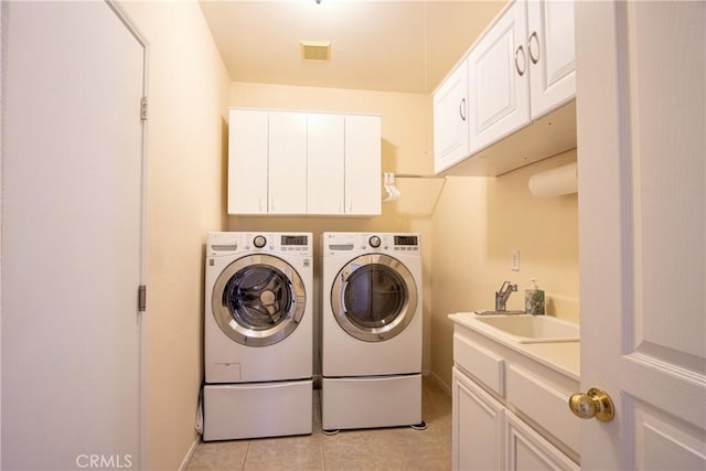 39312 Beringer Dr, Murrieta, CA 92563 - clothes washing area featuring separate washer and dryer, cabinet space, light tile patterned floors, and baseboards