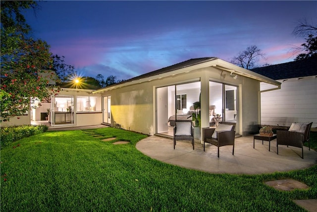 438 S Lamer St, Burbank, CA 91506 - back of house at dusk with a patio, a yard, and stucco siding