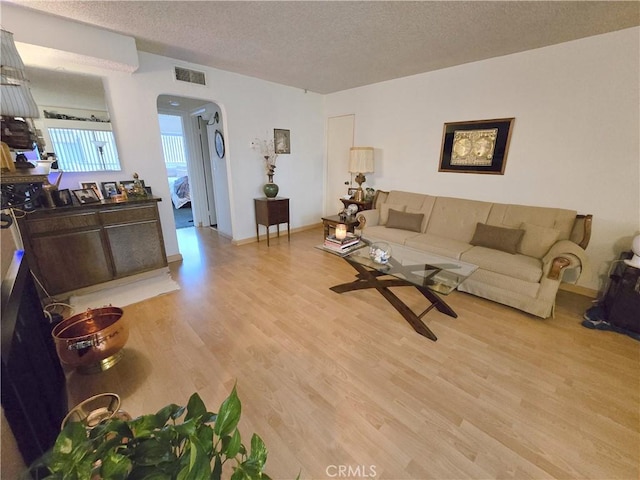 5805 Whitsett Ave Unit 102, Valley Village, CA 91607 - living area with arched walkways, a textured ceiling, visible vents, and wood finished floors