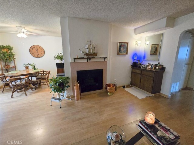 5805 Whitsett Ave Unit 102, Valley Village, CA 91607 - living room with a textured ceiling, ceiling fan, a fireplace with flush hearth, and light wood-type flooring
