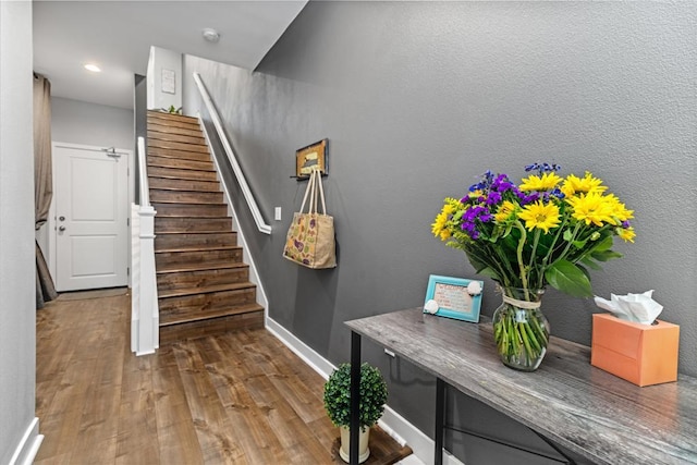 interior space with baseboards, recessed lighting, stairs, and wood finished floors