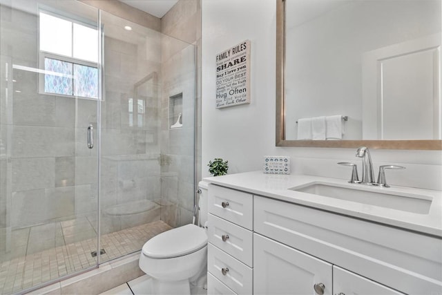 full bathroom with vanity, toilet, and a stall shower