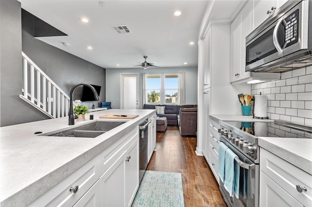 kitchen with visible vents, a sink, light countertops, open floor plan, and stainless steel appliances