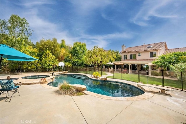view of swimming pool featuring a pool with connected hot tub, fence, and a patio