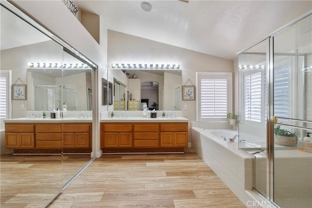 28433 Pinewood Ct, Saugus, CA 91390 - full bathroom with lofted ceiling, a garden tub, a stall shower, double vanity, and wood finished floors