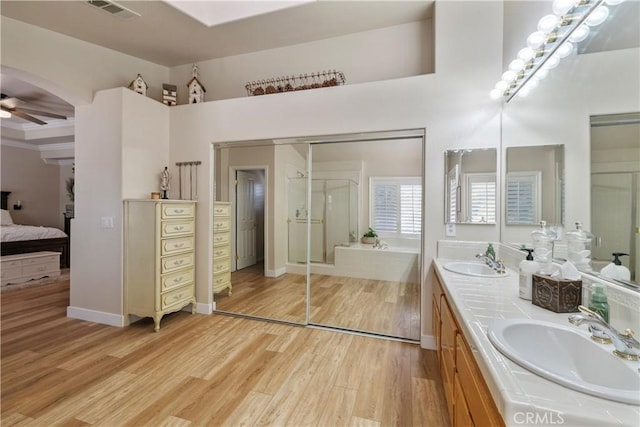28433 Pinewood Ct, Saugus, CA 91390 - bathroom with wood finished floors, double vanity, a shower stall, and ceiling fan
