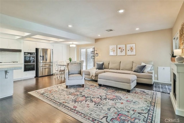 living room with visible vents, a fireplace, baseboards, dark wood-style floors, and recessed lighting