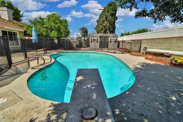view of swimming pool with a fenced backyard, a fenced in pool, a patio area, a storage shed, and an outbuilding