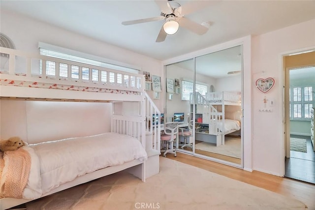 bedroom featuring ceiling fan, wood finished floors, and a closet
