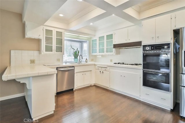 kitchen with decorative backsplash, dobule oven black, stainless steel dishwasher, a sink, and dark wood-type flooring