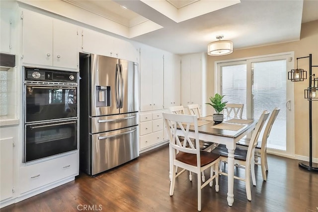 kitchen featuring white cabinets, stainless steel refrigerator with ice dispenser, dobule oven black, and dark wood finished floors