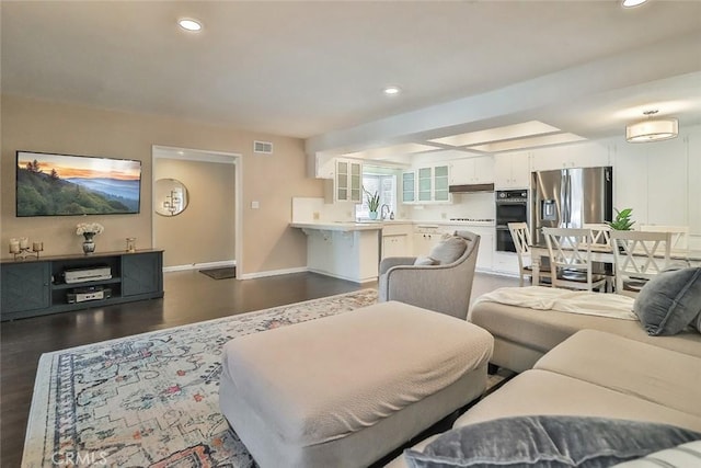 living room with recessed lighting, baseboards, visible vents, and dark wood finished floors