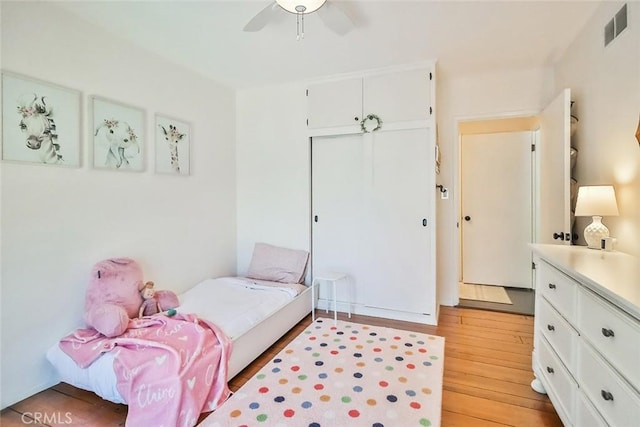 bedroom with ceiling fan, a closet, light wood-style flooring, and visible vents