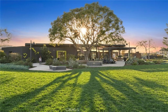 145 Novel, Irvine, CA 92618 - back of property at dusk featuring a lawn, a patio area, and a pergola
