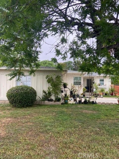 20243 Bassett St, Winnetka, CA 91306 - obstructed view of property with a front lawn and board and batten siding