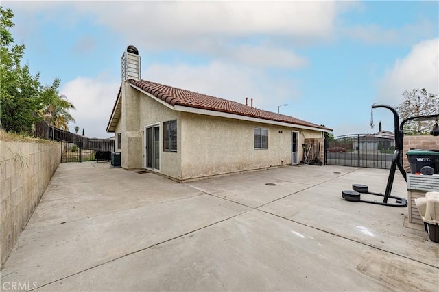 510 Monika Ct, Beaumont, CA 92223 - rear view of house featuring fence, stucco siding, a chimney, a patio area, and a tiled roof