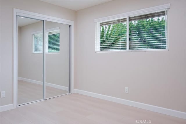 16840 Superior St, Northridge, CA 91343 - unfurnished bedroom featuring multiple windows, baseboards, a closet, and wood finished floors