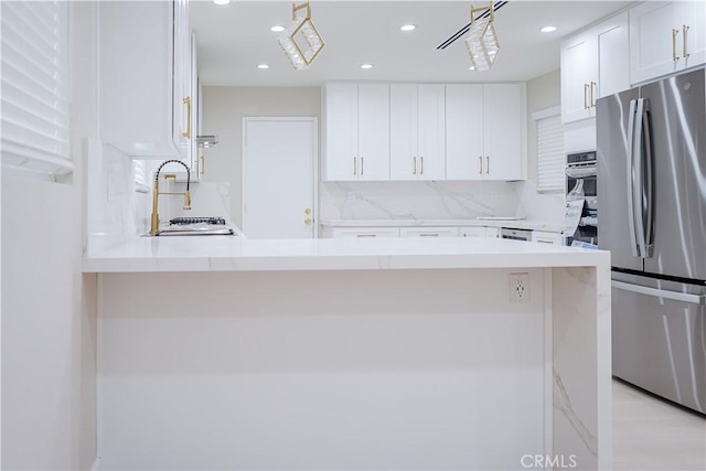 16840 Superior St, Northridge, CA 91343 - kitchen featuring stainless steel appliances, light countertops, white cabinets, a peninsula, and a sink
