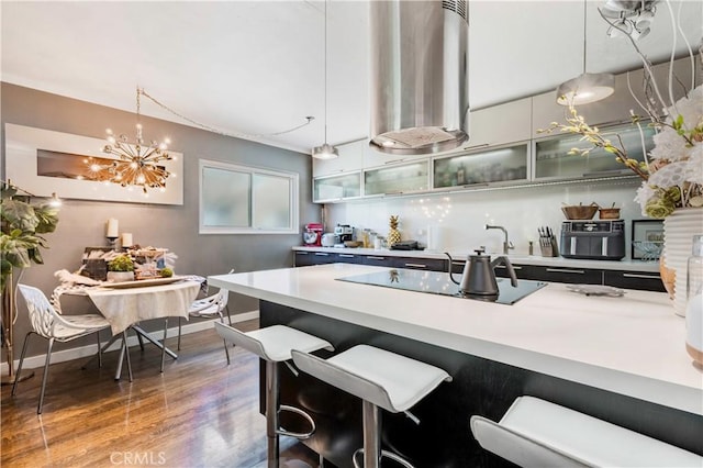 360 Obispo Ave Unit 15, Long Beach, CA 90814 - kitchen featuring wood finished floors, light countertops, decorative light fixtures, and a kitchen breakfast bar