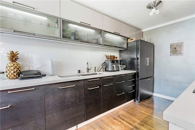 360 Obispo Ave Unit 15, Long Beach, CA 90814 - kitchen with freestanding refrigerator, light countertops, light wood finished floors, glass insert cabinets, and a sink