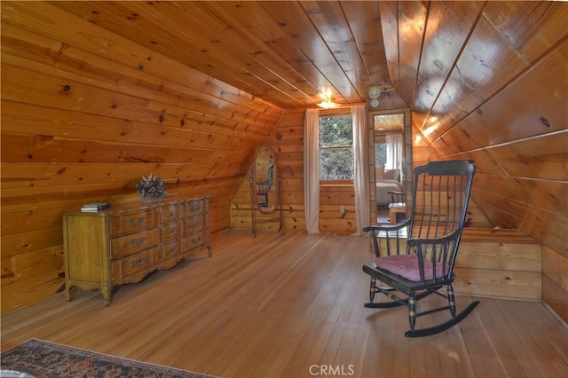living area with wooden walls, wood ceiling, hardwood / wood-style flooring, and lofted ceiling