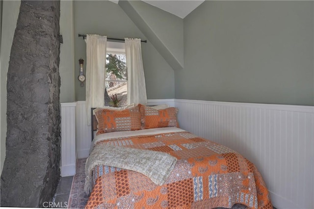 bedroom featuring a wainscoted wall