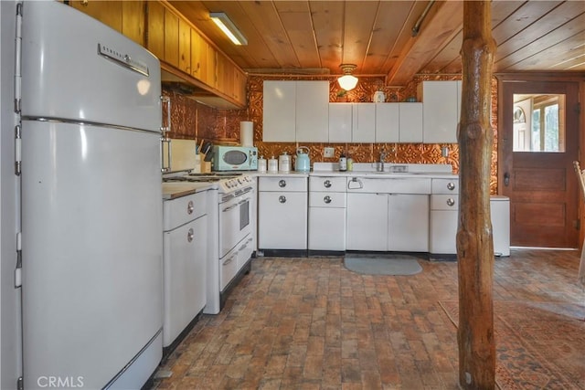 kitchen with brick floor, freestanding refrigerator, white cabinetry, white gas stove, and wood ceiling