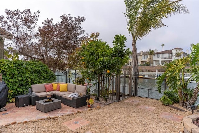 view of patio featuring a water view, a gate, fence, and an outdoor hangout area