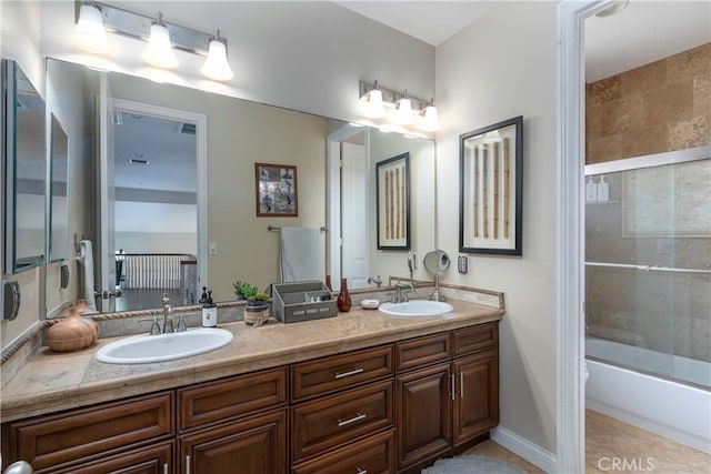 full bath featuring double vanity, a sink, combined bath / shower with glass door, and tile patterned floors