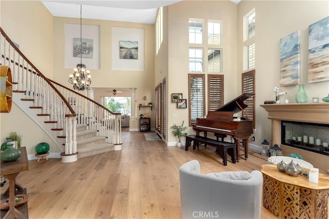 entryway with stairs, baseboards, a chandelier, and a towering ceiling