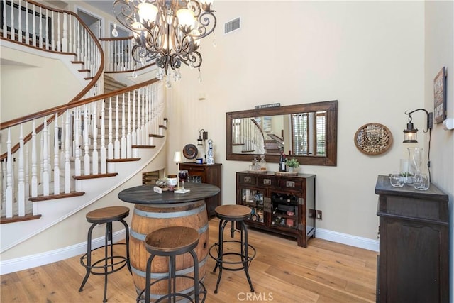 interior space with stairs, baseboards, visible vents, and wood finished floors