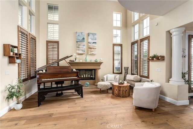 4027 W Hemlock St, Oxnard, CA 93035 - sitting room featuring a high ceiling, light wood-style flooring, ornate columns, and baseboards
