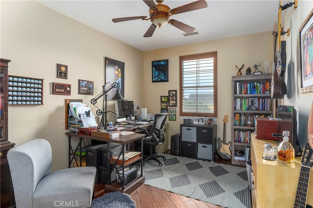office with ceiling fan, visible vents, and wood finished floors