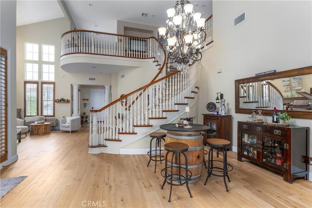interior space with stairs, high vaulted ceiling, visible vents, and hardwood / wood-style floors